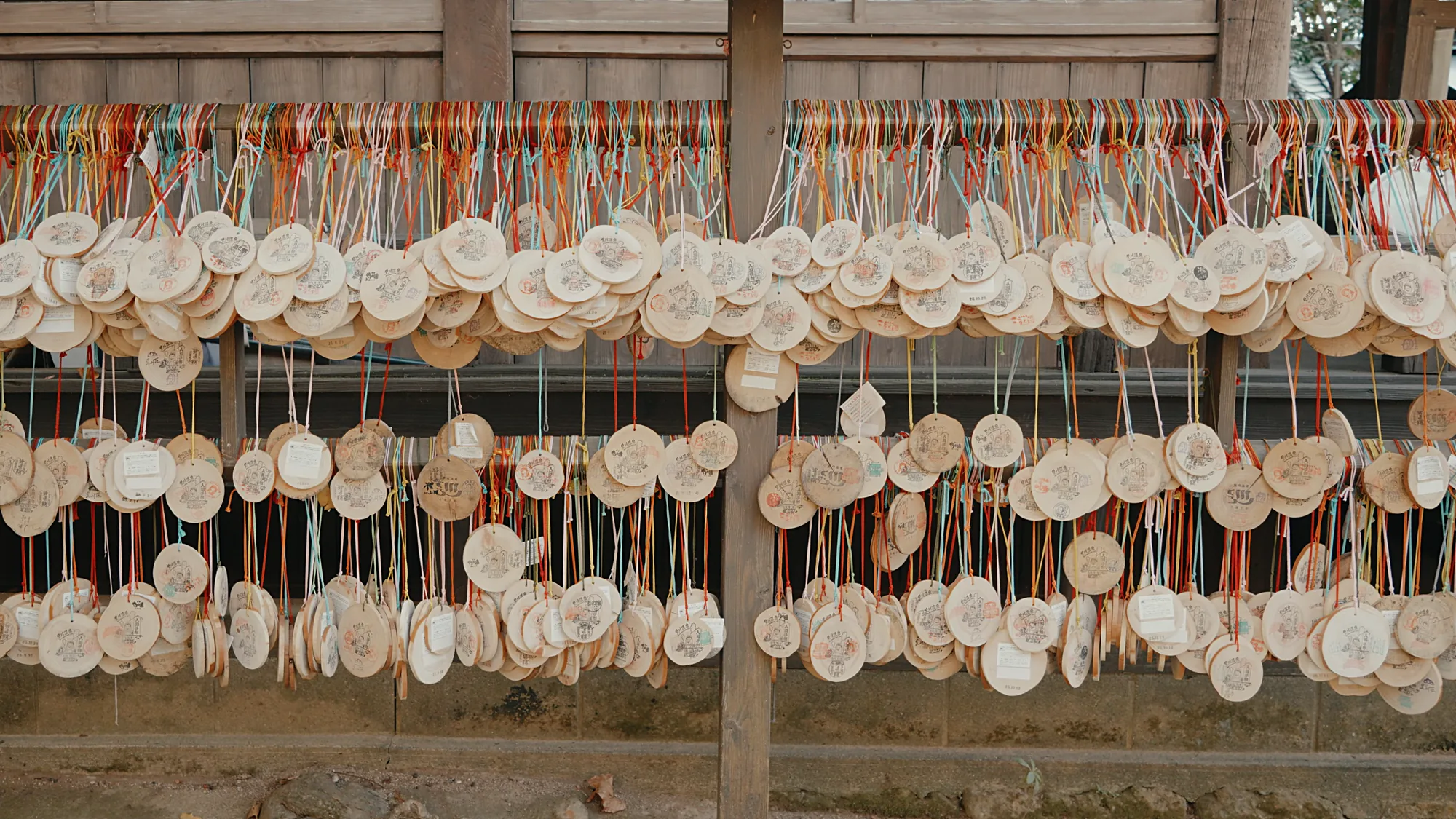 A wall of wooden nyuto tegata discs hung on cords, the bathing pass used across Kurokawa Onsen