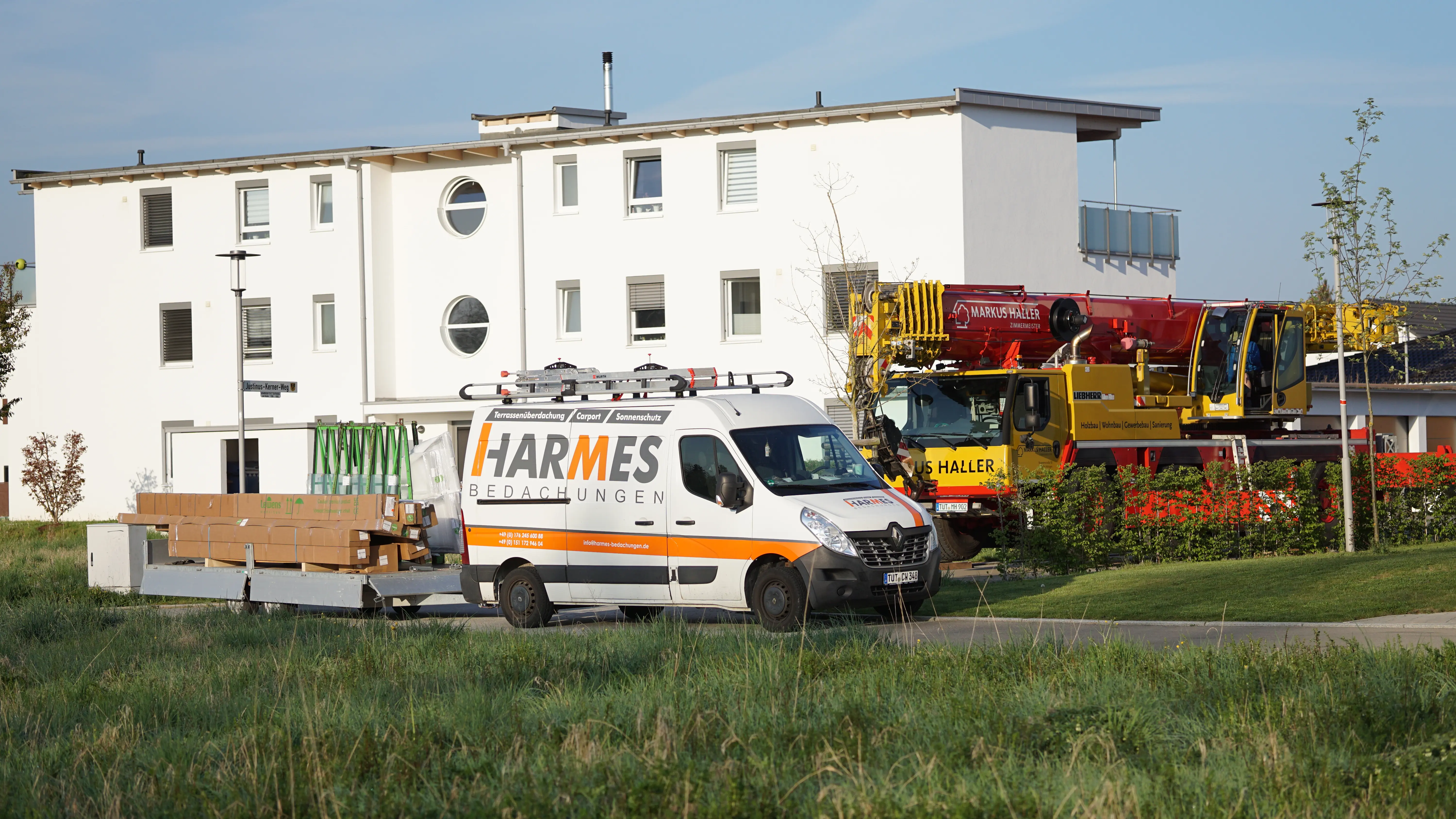 Firmenfahrzeug von Harmes Bedachungen mit Kran auf einer Baustelle