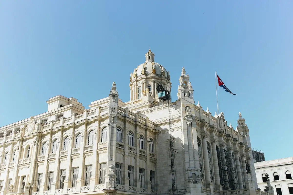 Neoclassical Neoclassicistisch gebouw met koepel en Cubaanse vlag onder een heldere blauwe luchtwith dome and Cuban flag under a clear blue sky