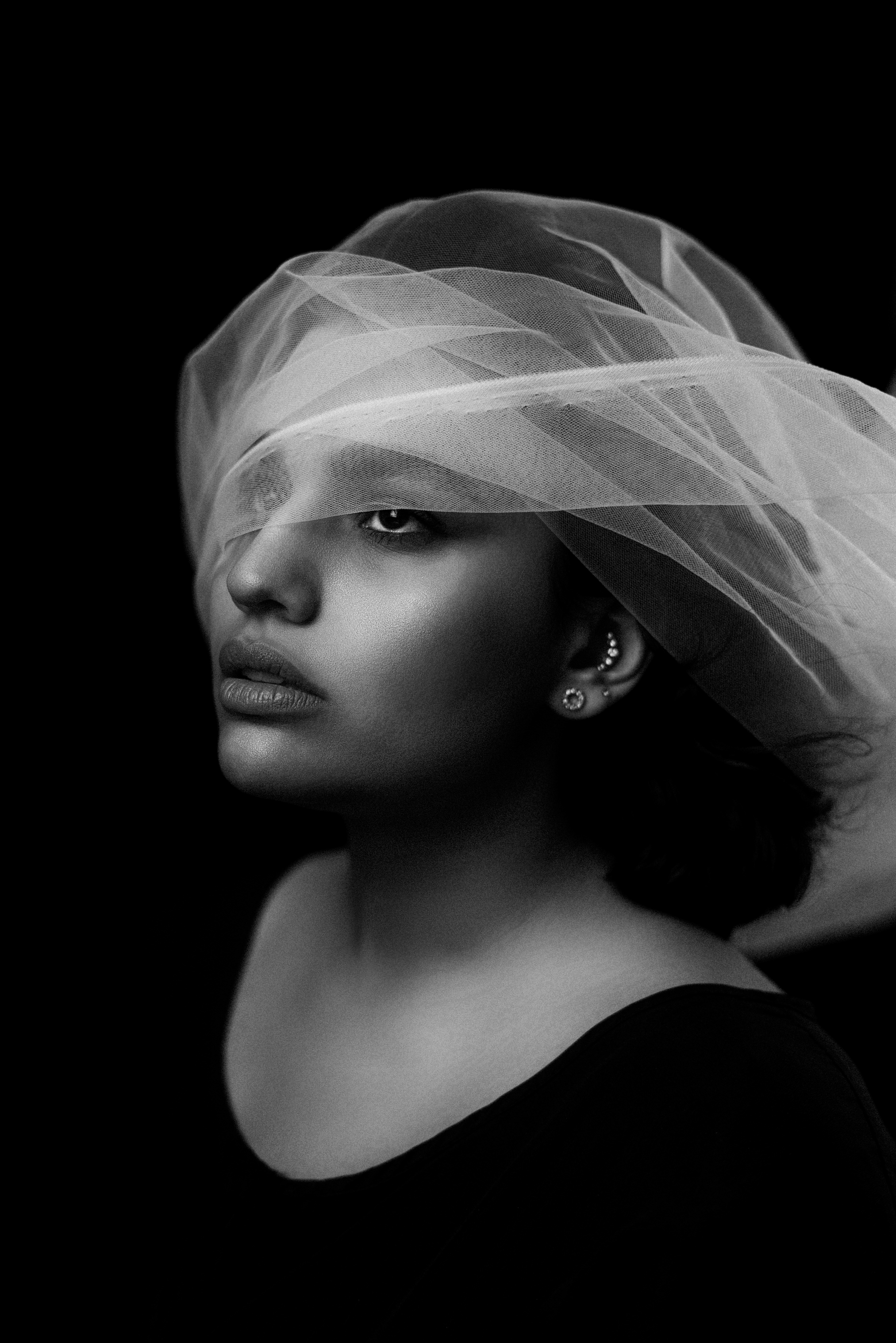 Woman with sheer fabric draped over her face