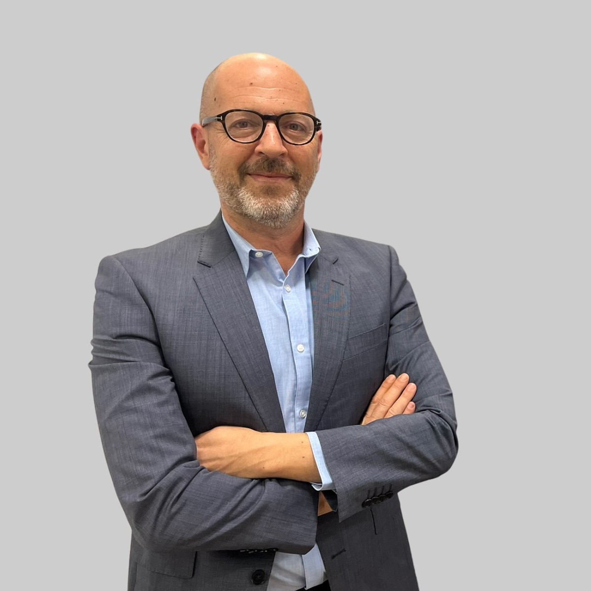 A person with medium-length brown hair wearing a dark, textured coat and a burgundy turtleneck. They have a calm, neutral expression.