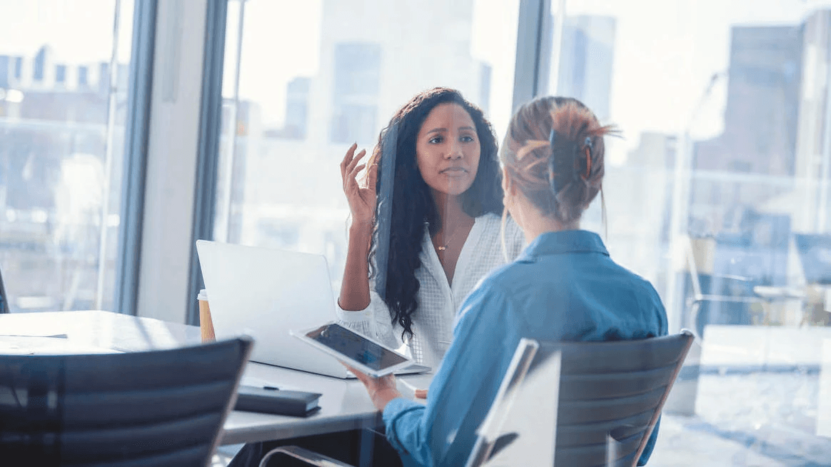 Employee in a difficult workplace conversation during a layoff-related meeting.