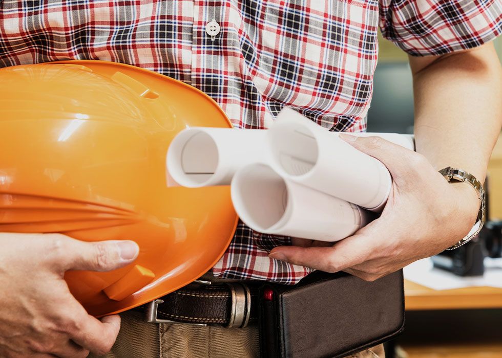 Modern glass building with illuminated facade and cityscape view at sunset