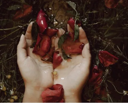 Yäan Spa at Be Tulum: woman relaxing and enjoying a massage, with a masseuse performing techniques, and a lit candle in the background for ambiance.