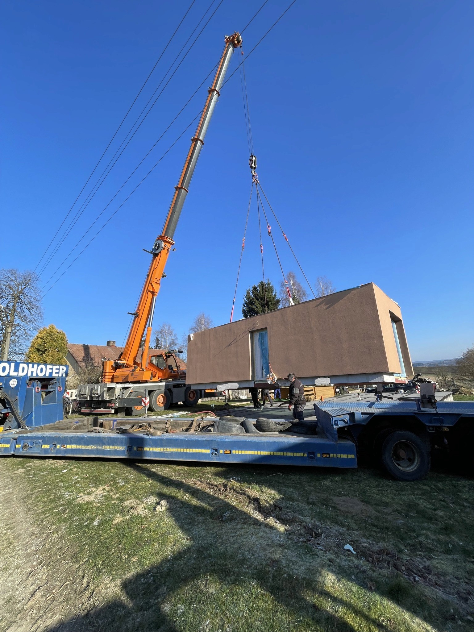 Fotka jeřábu který pokládá modul