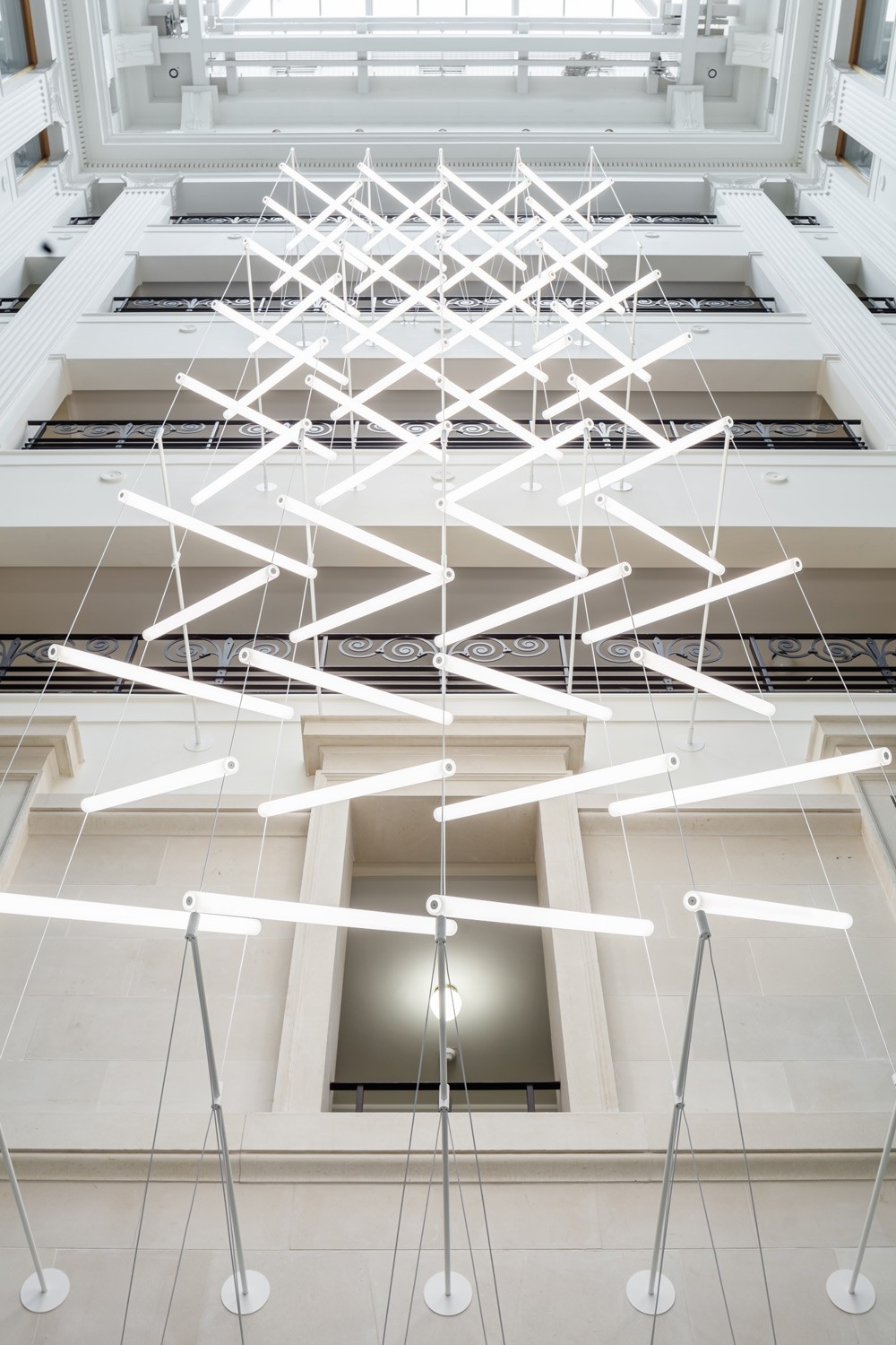 Close-up of custom acrylic LED light units suspended on tensioned steel cables