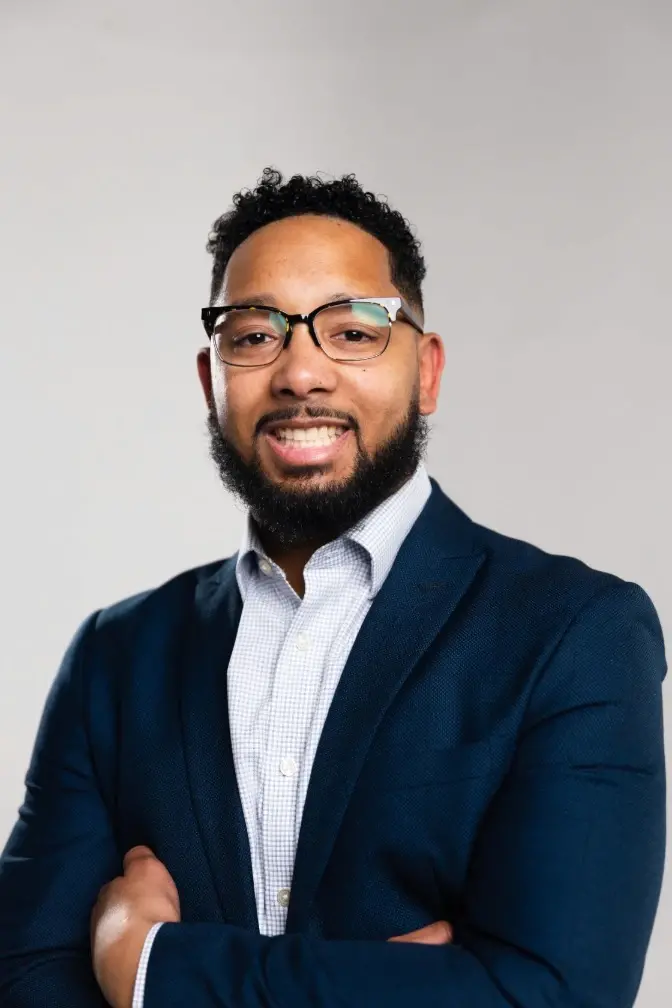 Chris Lewis, mortgage loan expert, smiling confidently in a navy suit and white shirt. The professional portrait conveys trust, expertise, and personalized service from Chris Lewis Home Loans.