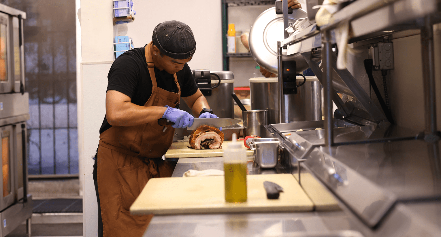 chef in kitchen cutting meat.