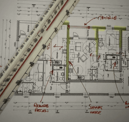 Marked-up architectural plans reviewed for structural engineering design and project constraints