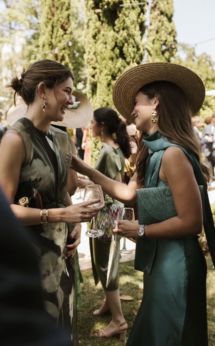 Group of hikers walking through a mountain meadow surrounded by pine trees and misty peaks.