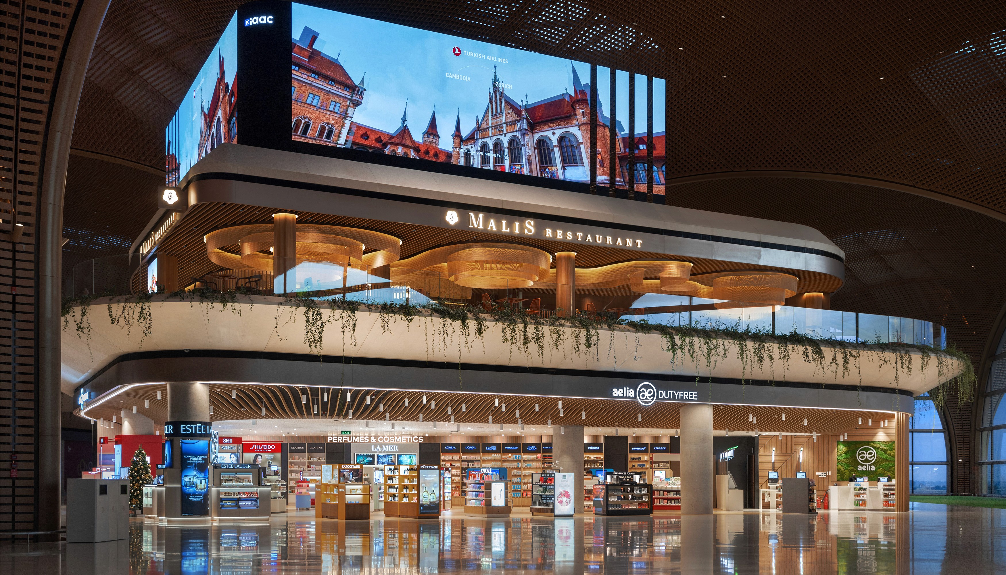 Architectural view of the elevated Malis Restaurant at Techo International Airport positioned above the Aelia Duty Free retail zone showcasing the seamless integration of hospitality and luxury retail within the terminal