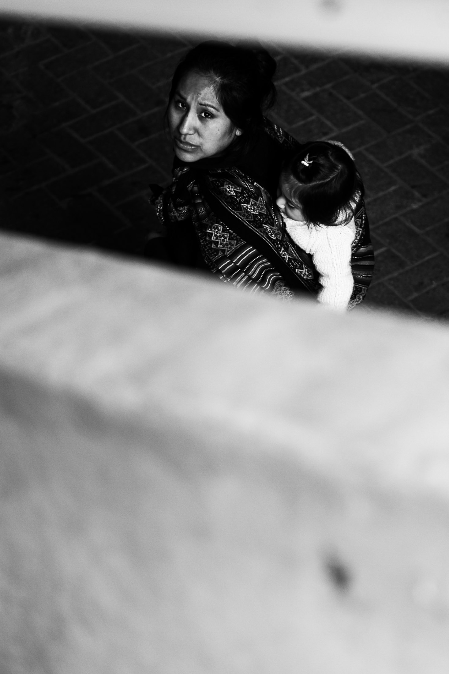 Black and white photograph of elderly woman wearing hat sitting by window inside public transport.