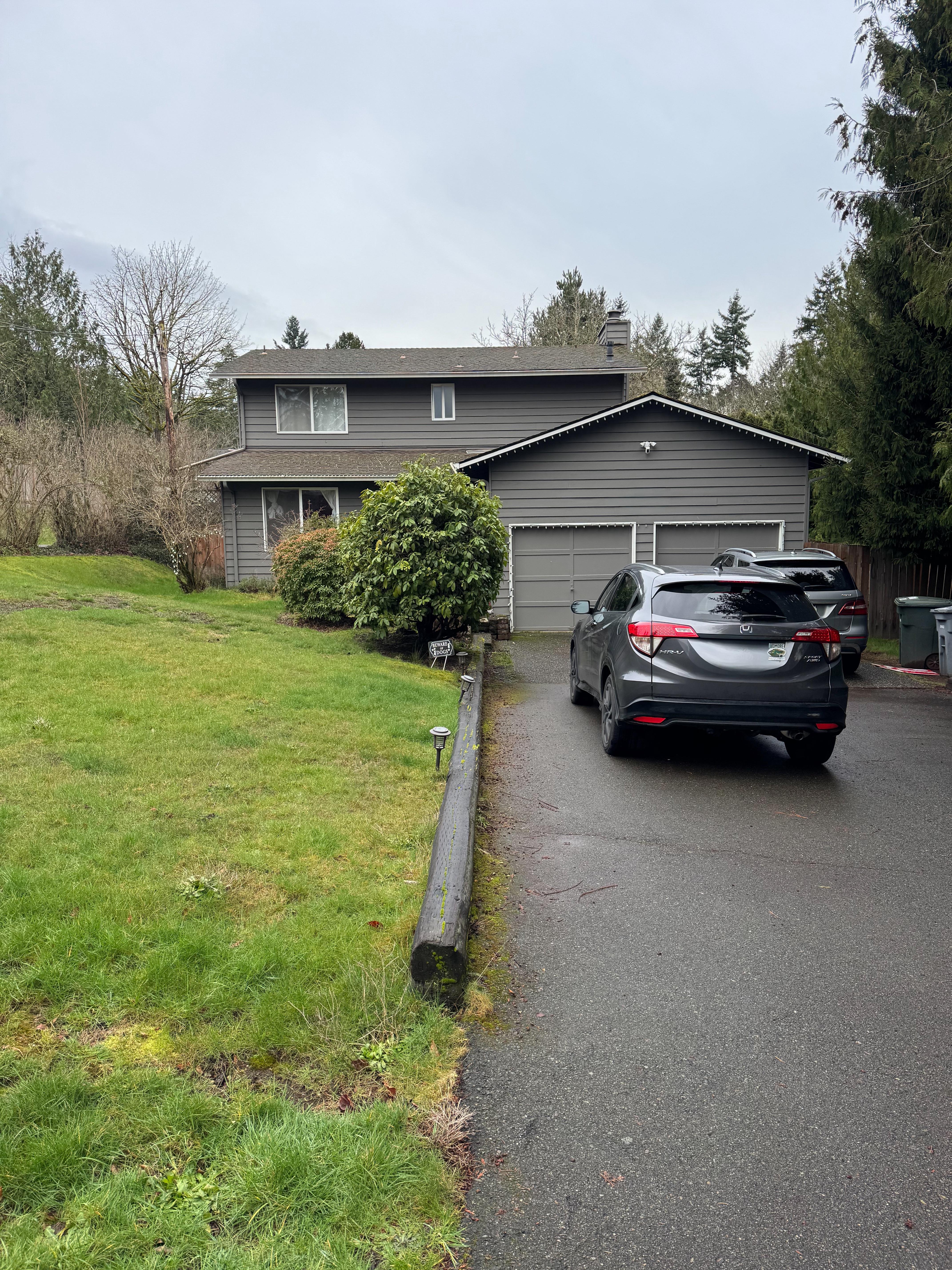 Brick house exterior before update — gray split-level with attached garage in PNW