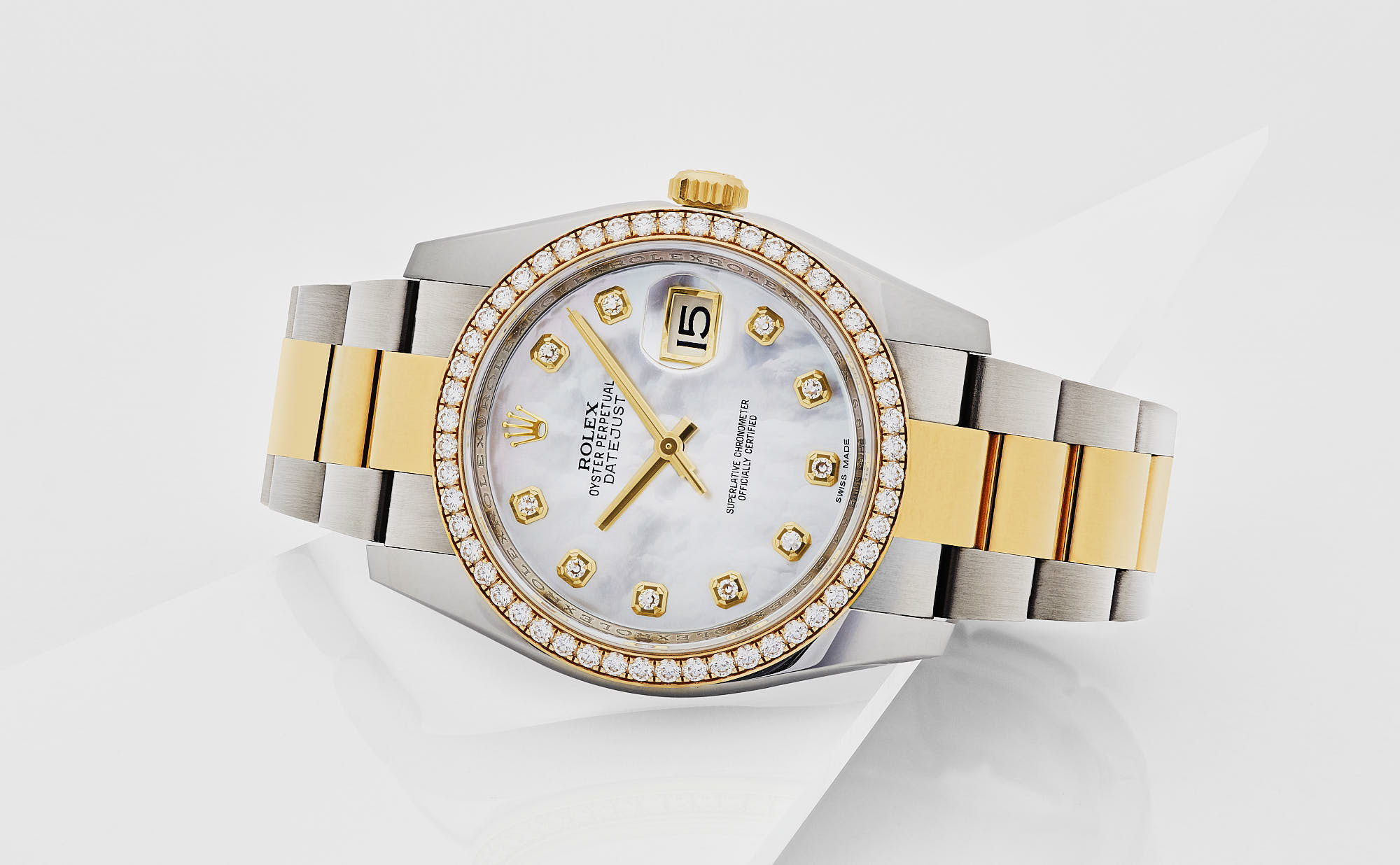 Luxury gold and silver wristwatch with diamond bezel and date display.