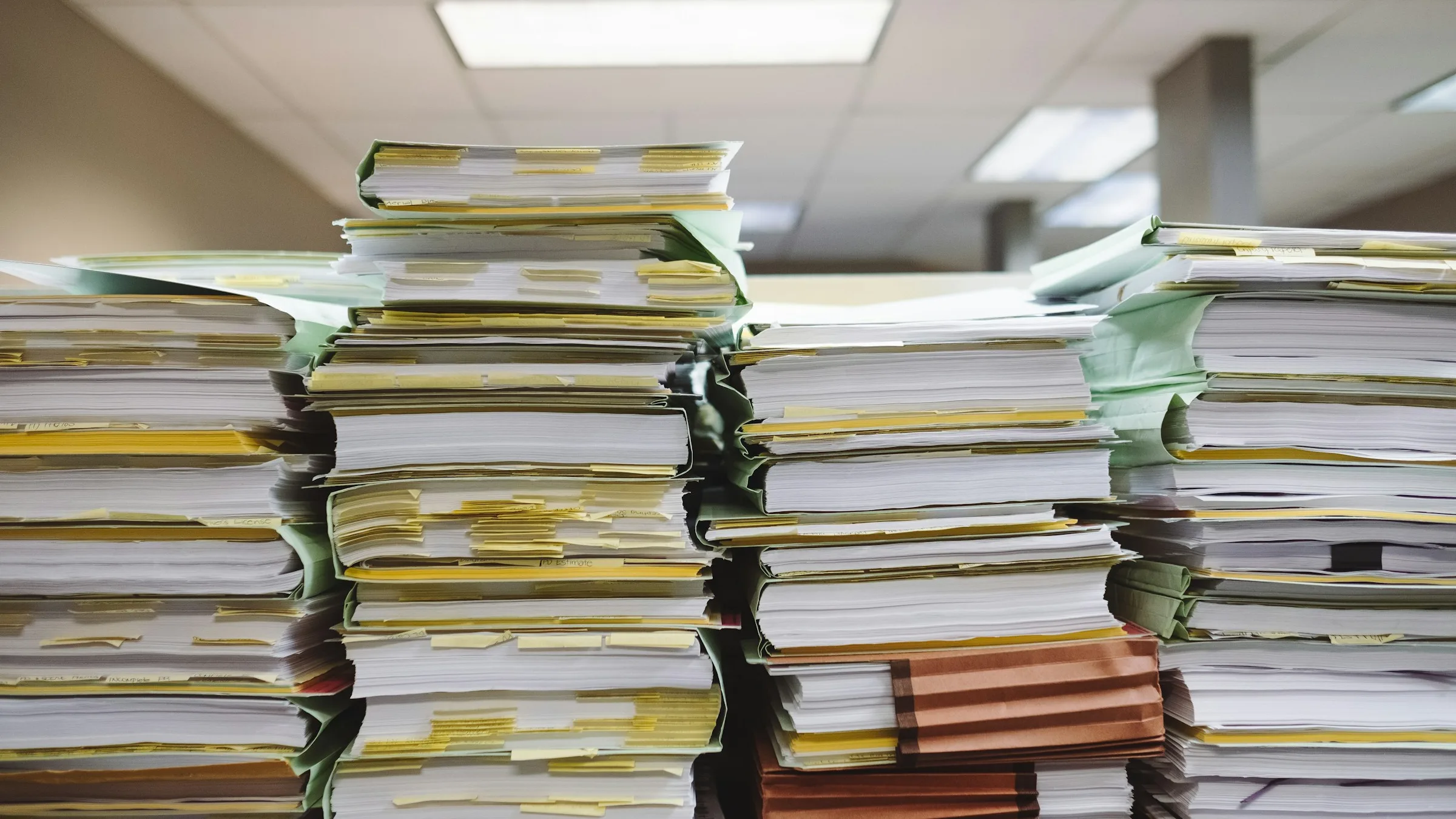Tall stacks of paper files and binders in an office, representing tax records and credit carryforward documentation
