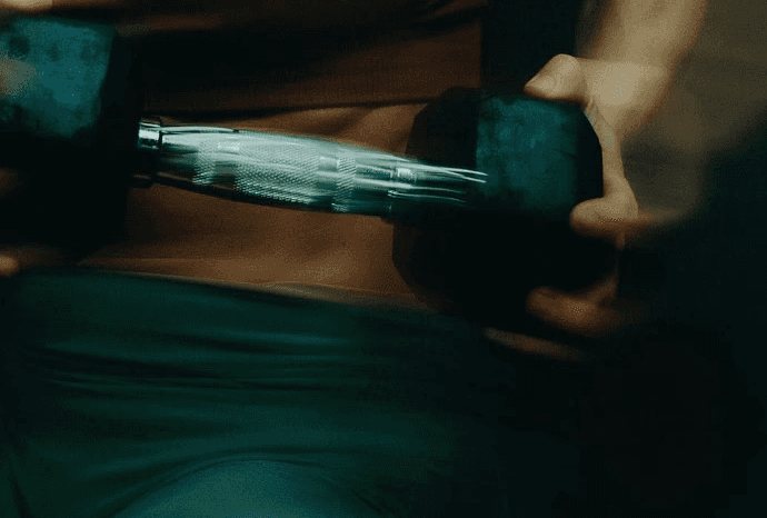 Detalle de mancuerna en un entrenamiento de fuerza, con el brazo en movimiento