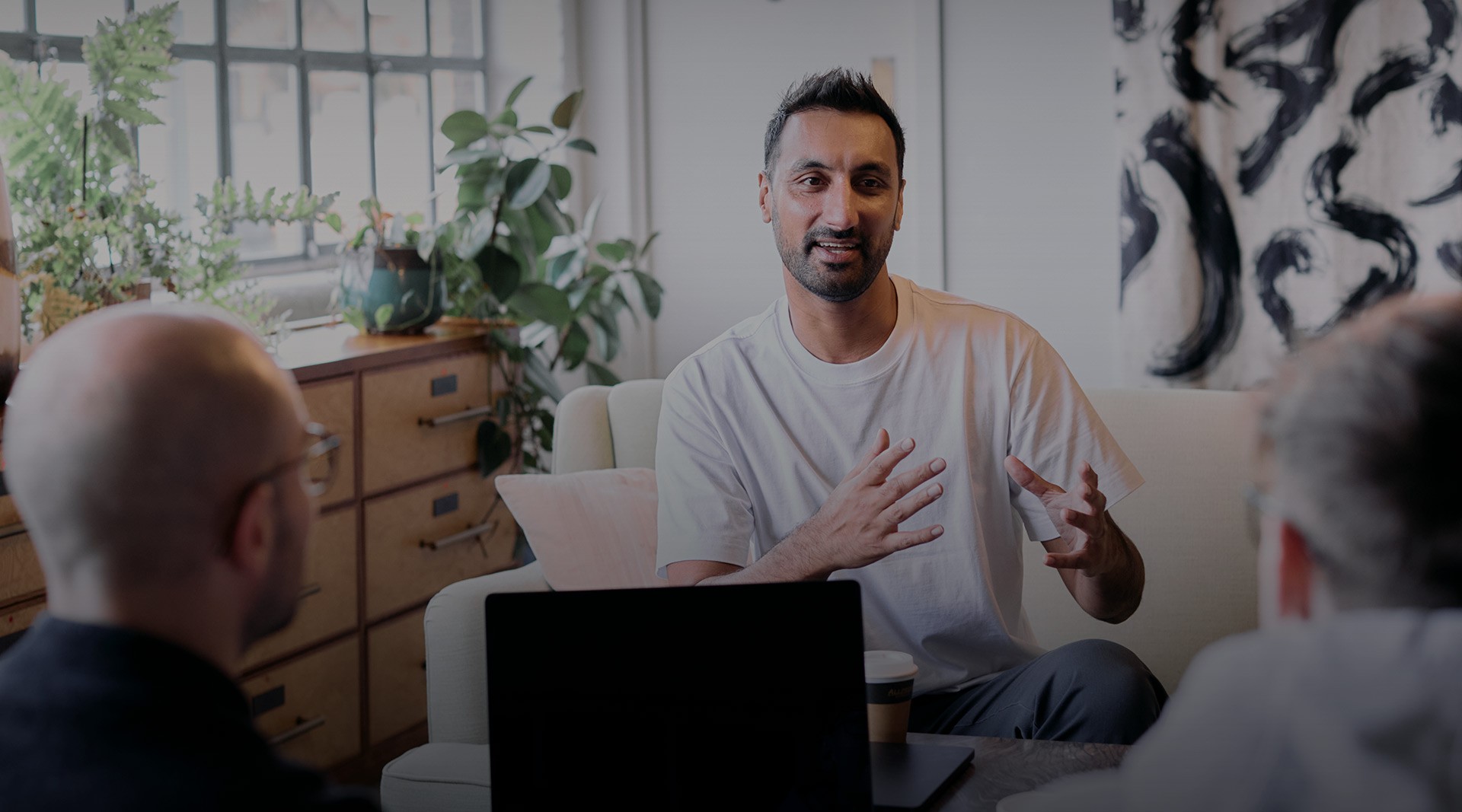 Person speaking during an informal meeting in a modern office setting for Valliance's Get in touch page.