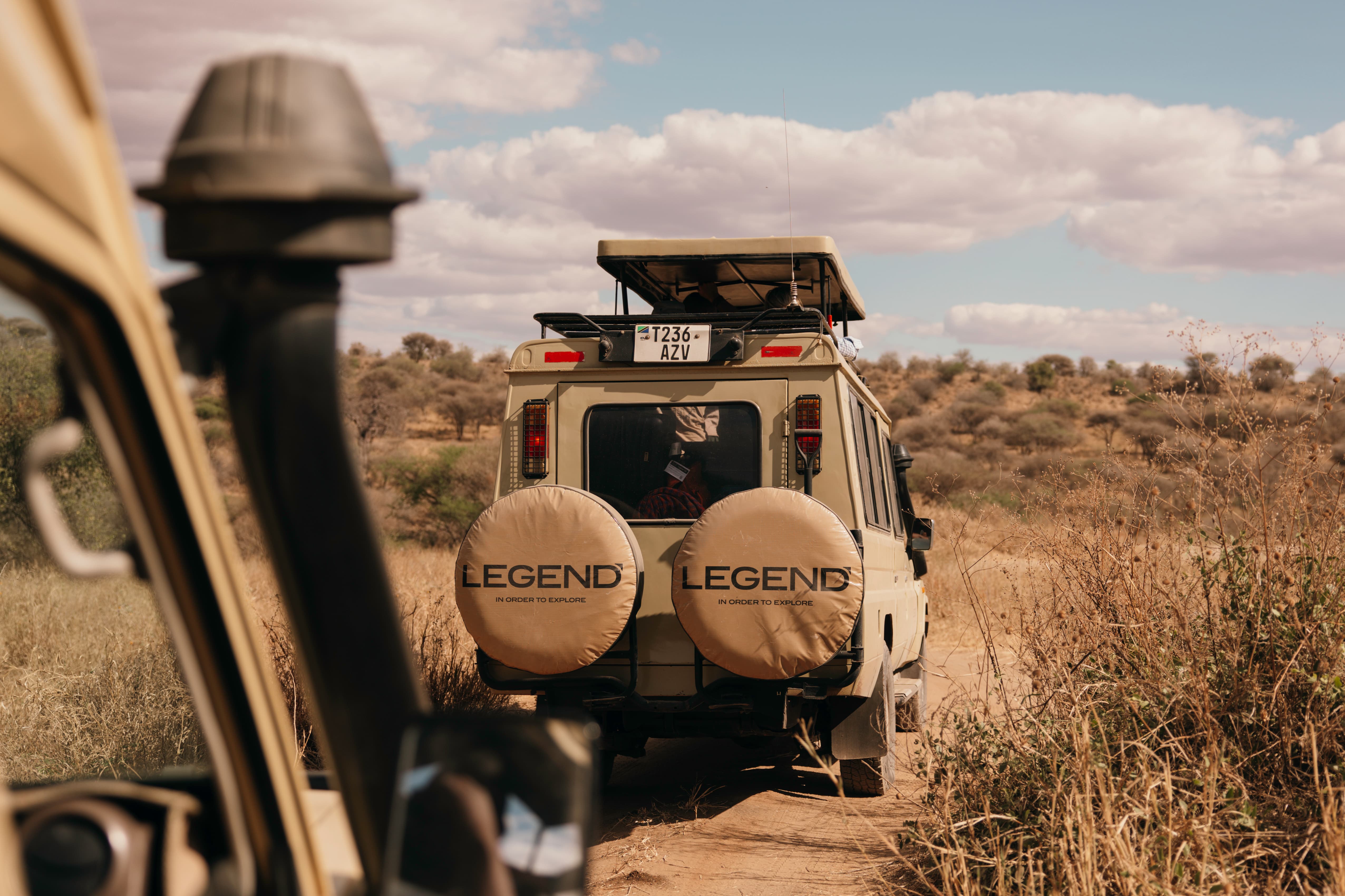A Legend Expeditions safari Land Cruiser with Mount Kilimanjaro in the background, showing the combined climb and safari package.