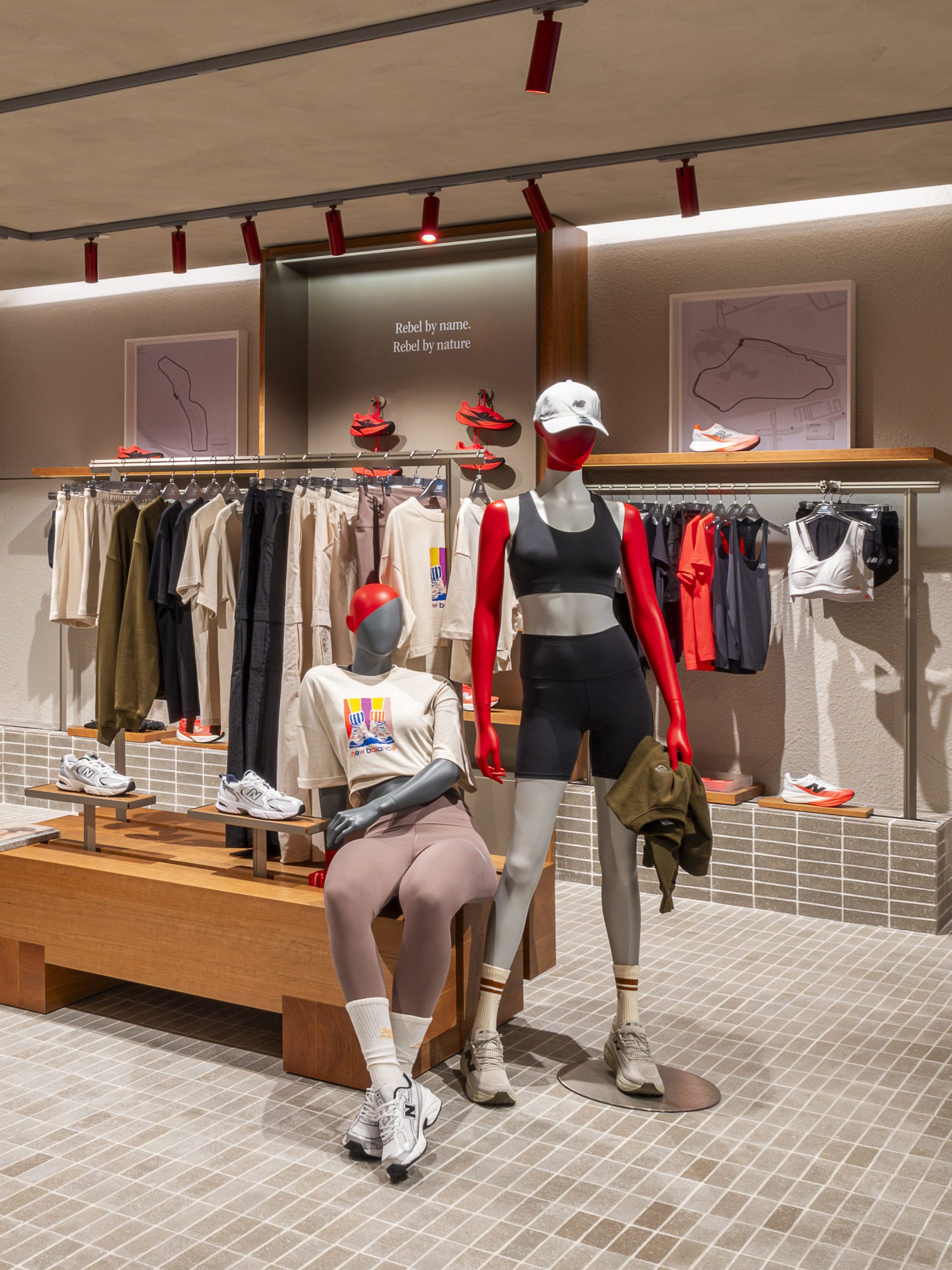 Interior of the New Balance Run Hub at Suria KLCC, showcasing clothing displays and mannequins dressed in athletic wear.