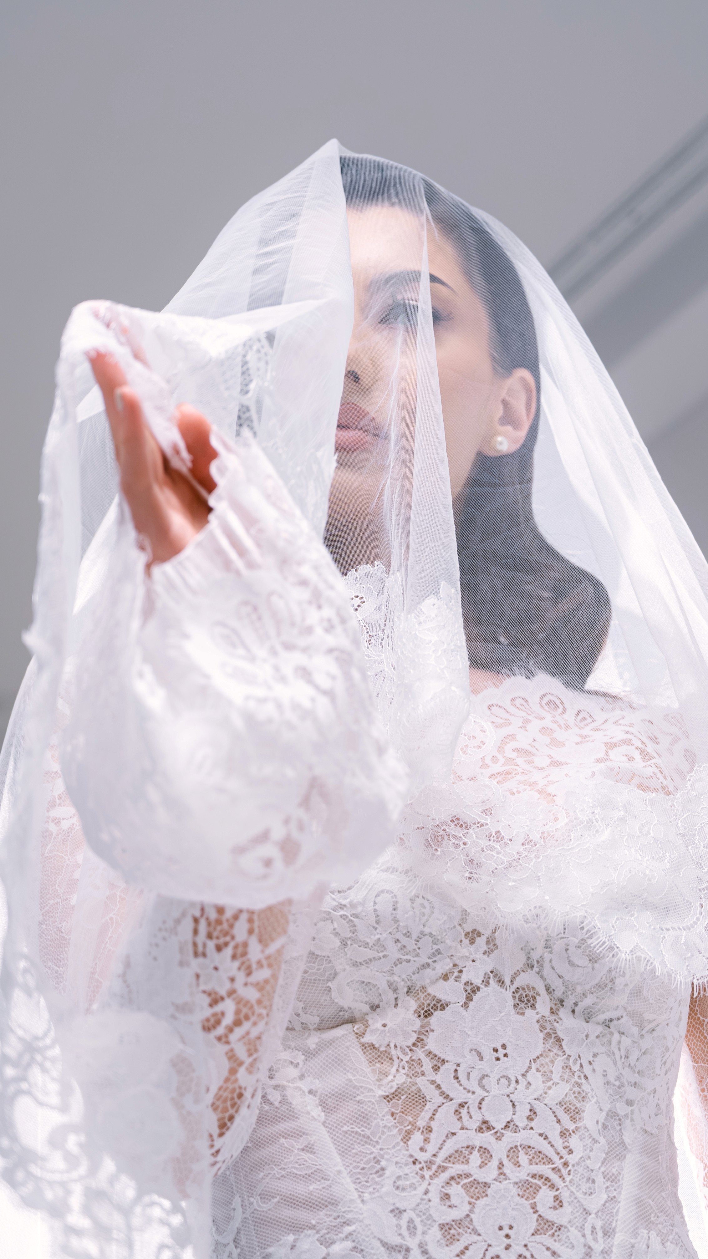 Mireasă fotografiată prin voal într-un decor luminos și elegant, ședință foto de nuntă în București