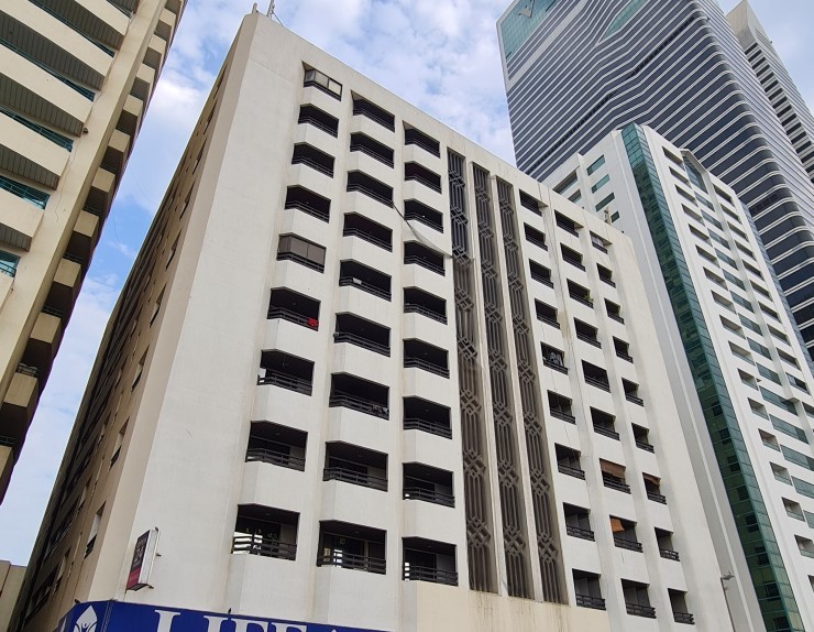 White Swan Building street view featuring Life Pharmacy and Zoom Market, prime real estate for lease.