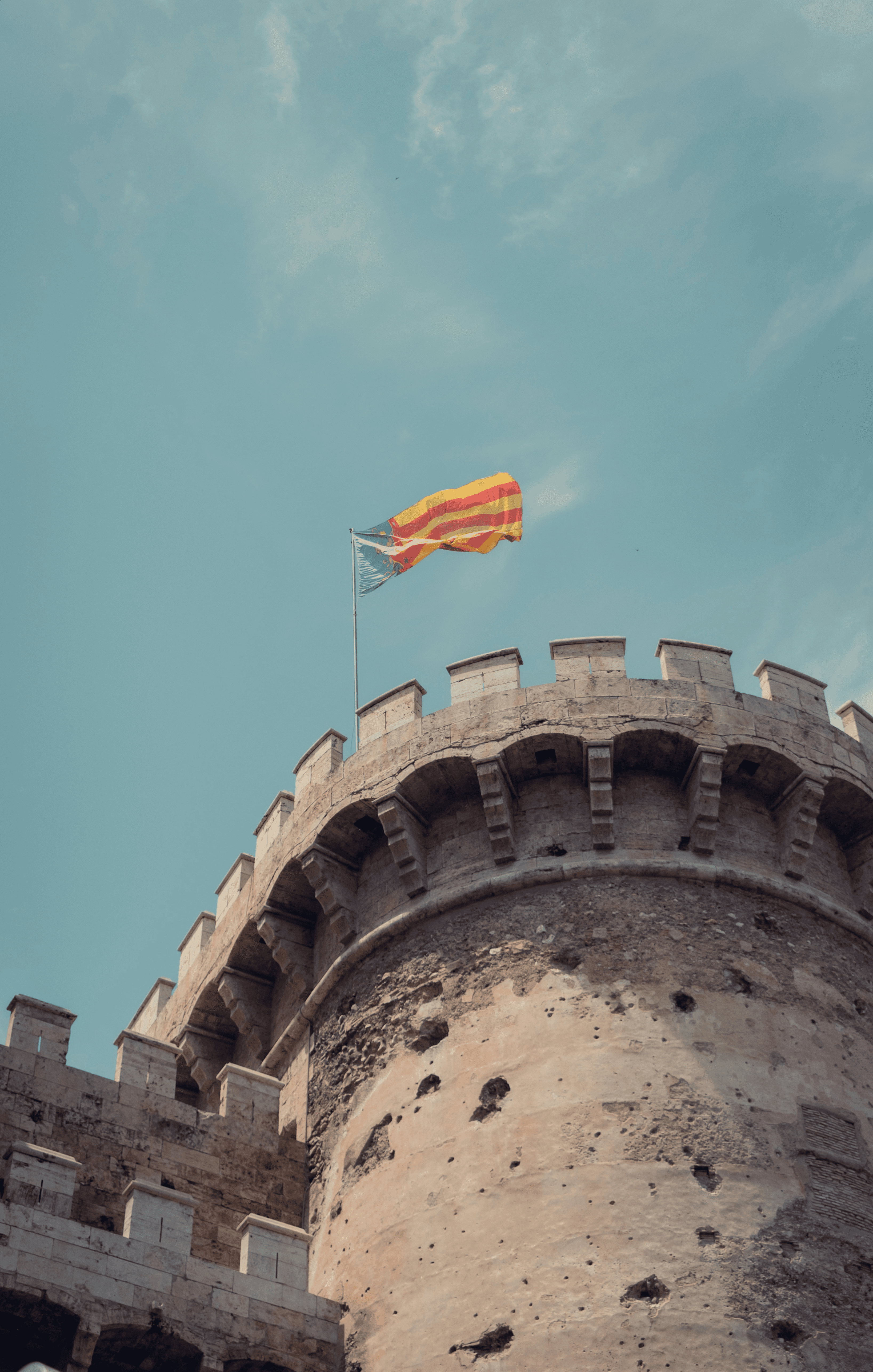 a yellow and red flag flying on top of a castle