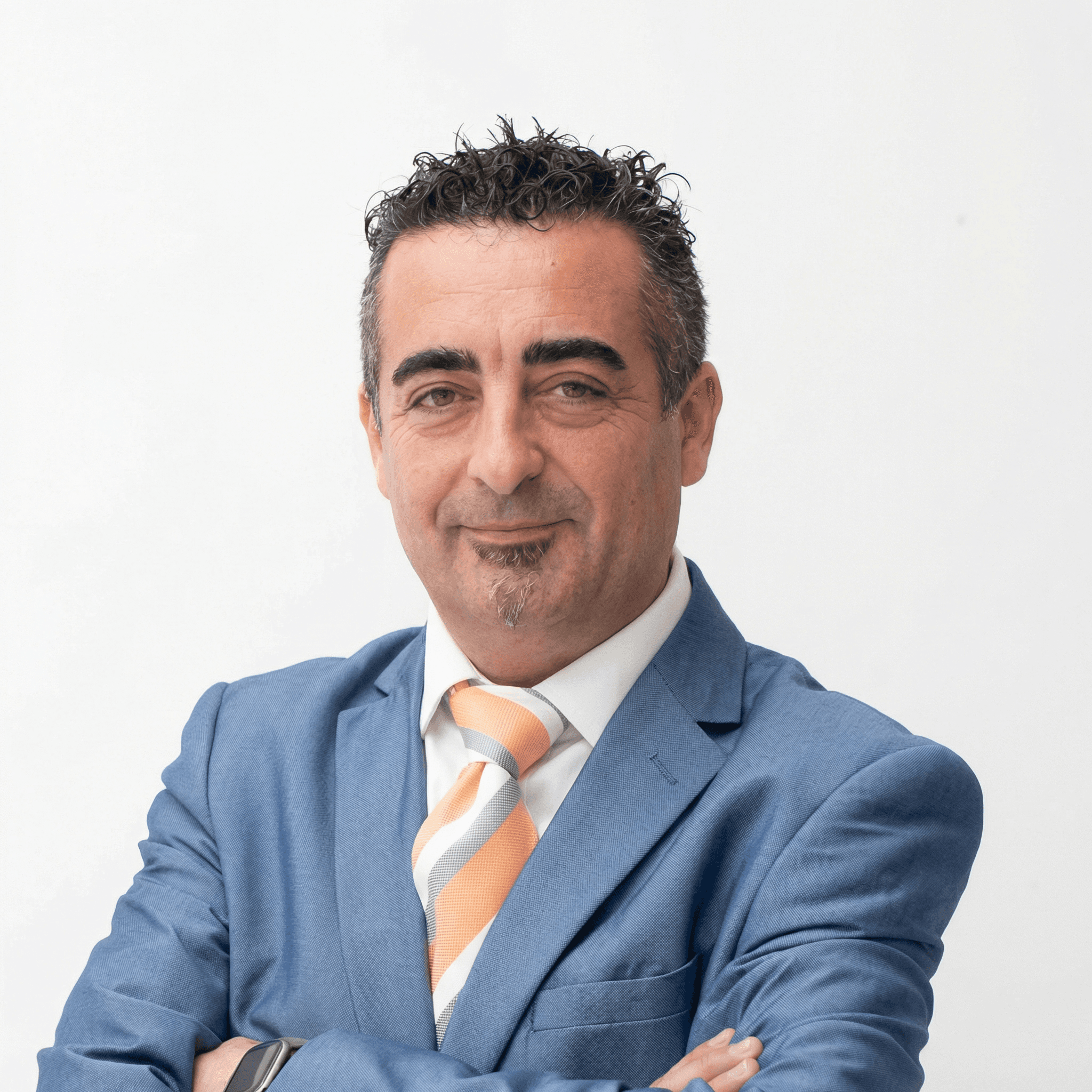 Man in glasses wearing a grey suit and blue tie, looking at the camera with a calm expression.