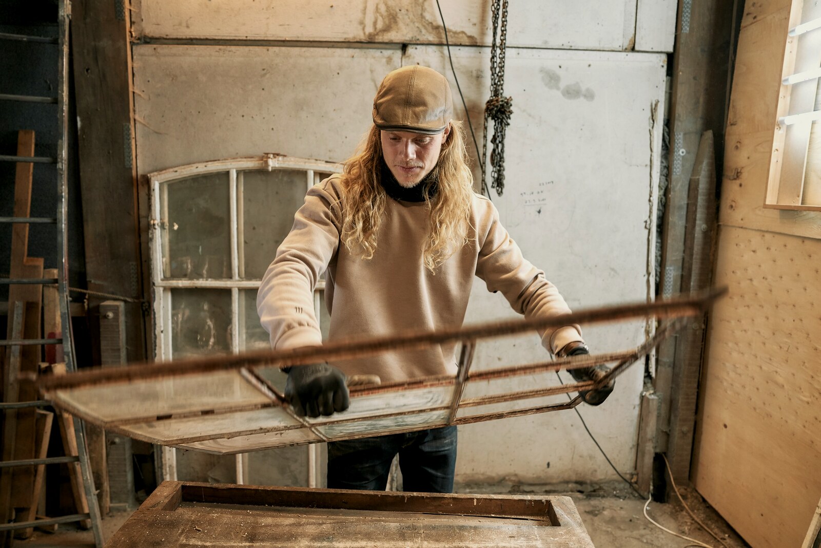 Carrying a glazed frame across the workshop