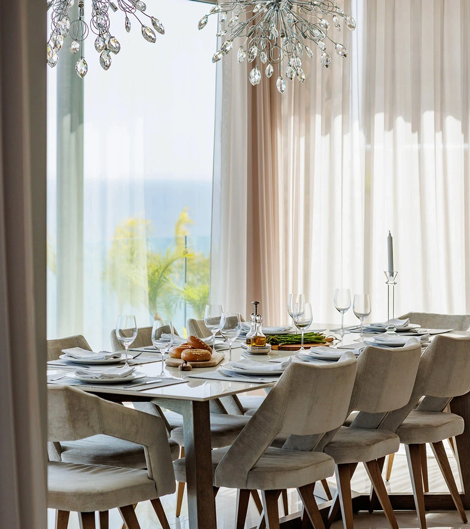 Seafront Residence Limassol dining table styled for entertaining with neutral upholstered chairs and sea-view backdrop