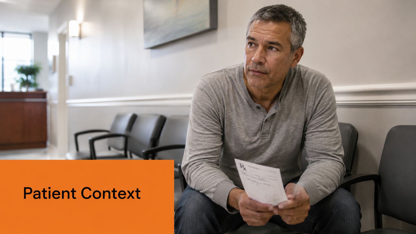 A middle-aged man sitting in a clinic waiting area holding a medical prescription in his hands.