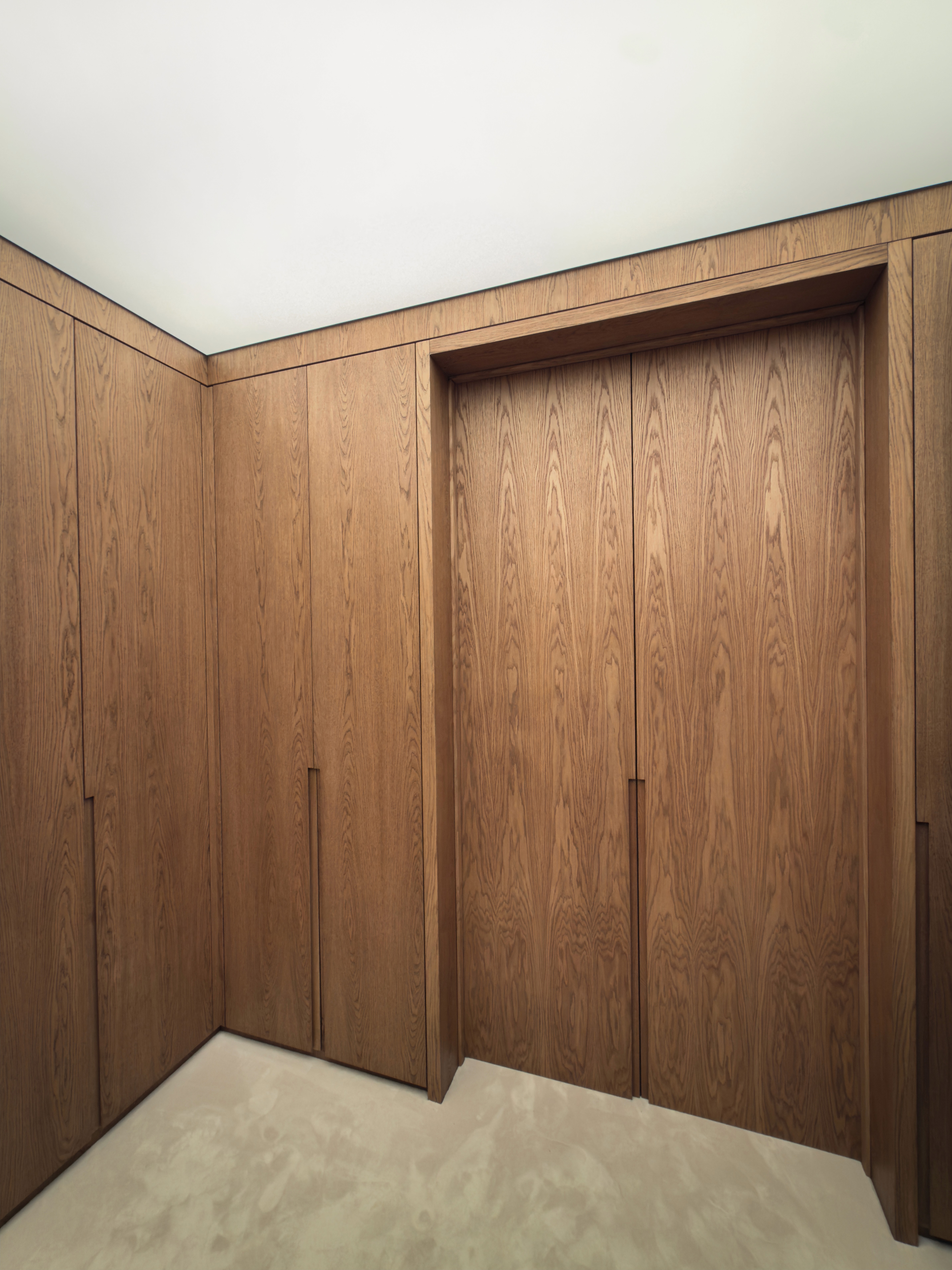 Minimal oak wardrobe joinery detail with ceiling light box
