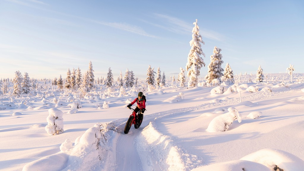 a person riding a snow bike on a snowy surface
