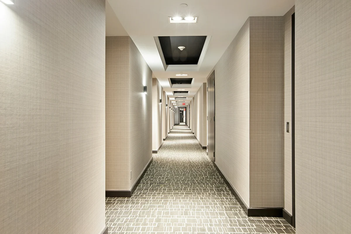 Guest room corridor with patterned carpet.