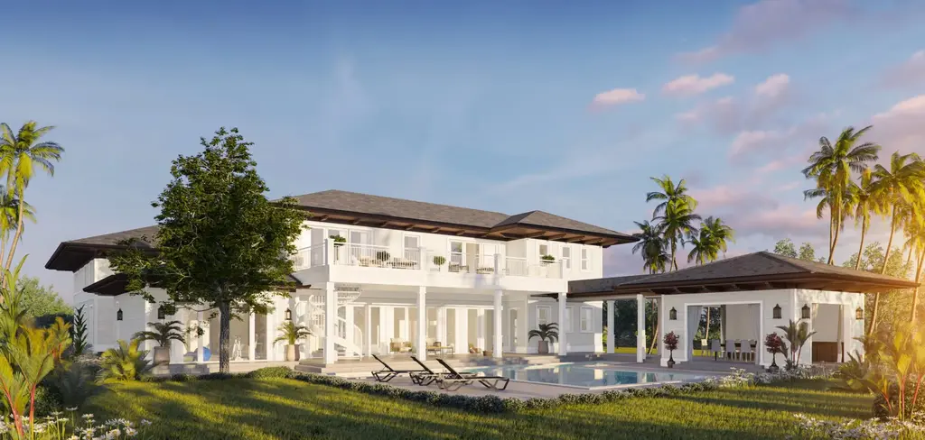 Wide rear elevation of a Coconut Grove Colonial estate showing the symmetrical massing, pool, detached pavilion, and surrounding palm trees at sunset.