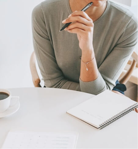woman thinking with pen to mouth