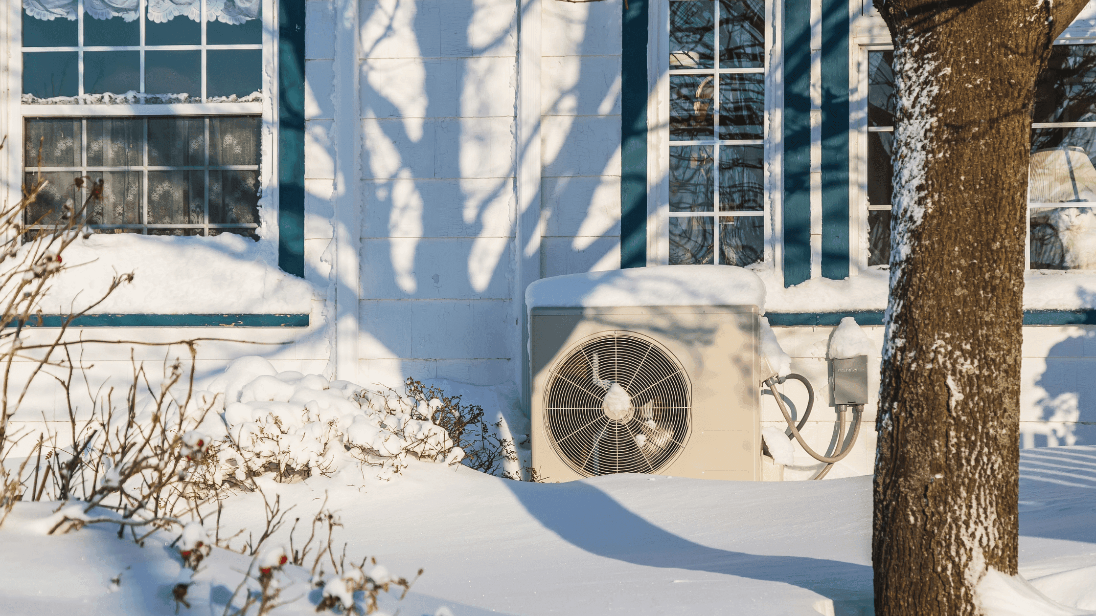 Wärmepumpe im Schnee vor einer Hauswand