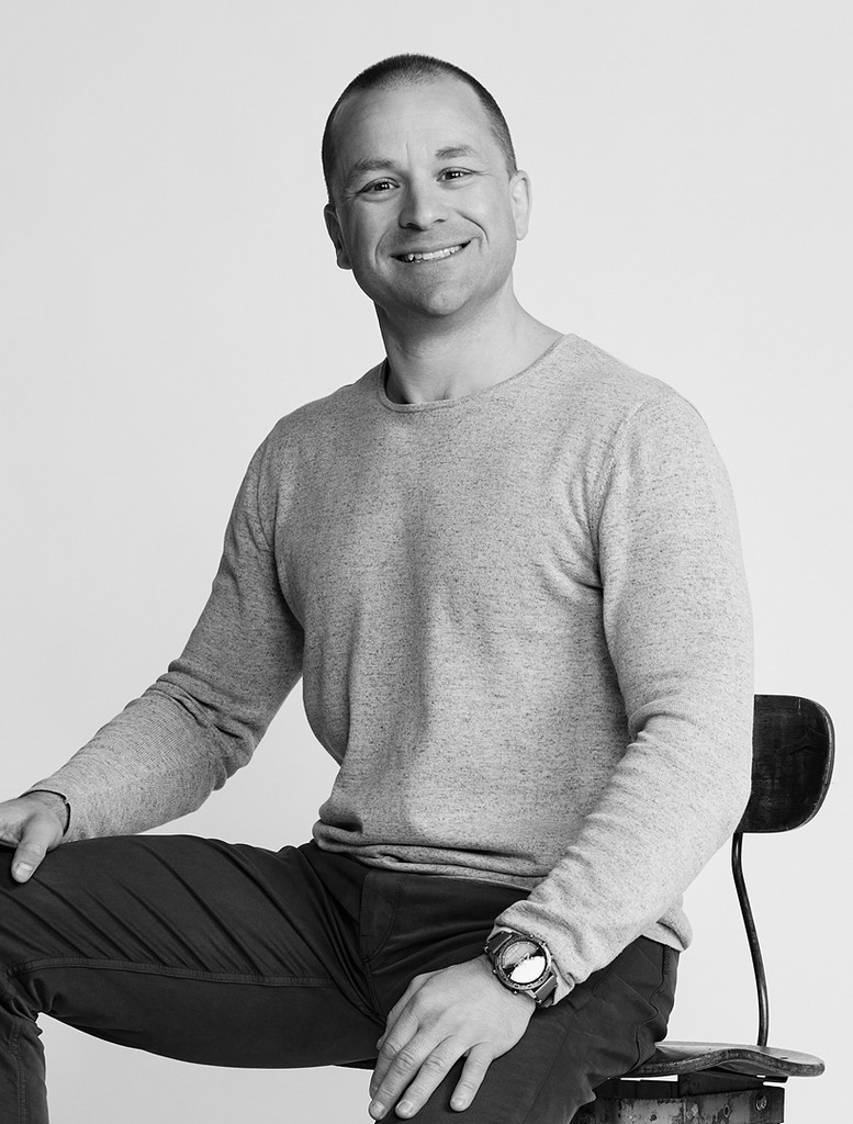 Black and white portrait of a smiling person with curly hair