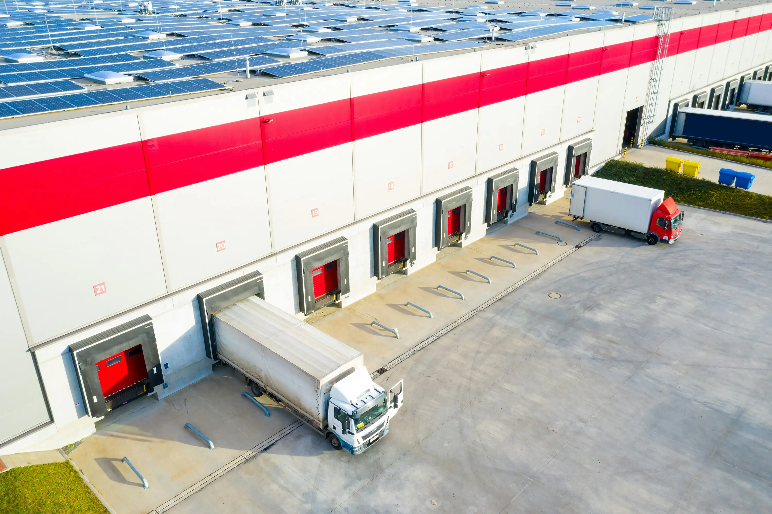 a close-up of a warehouse loading bay with lorries parked outside