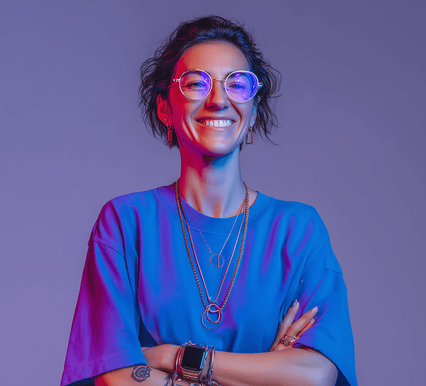 A woman in a blue shirt and glasses, posing confidently with a friendly expression.