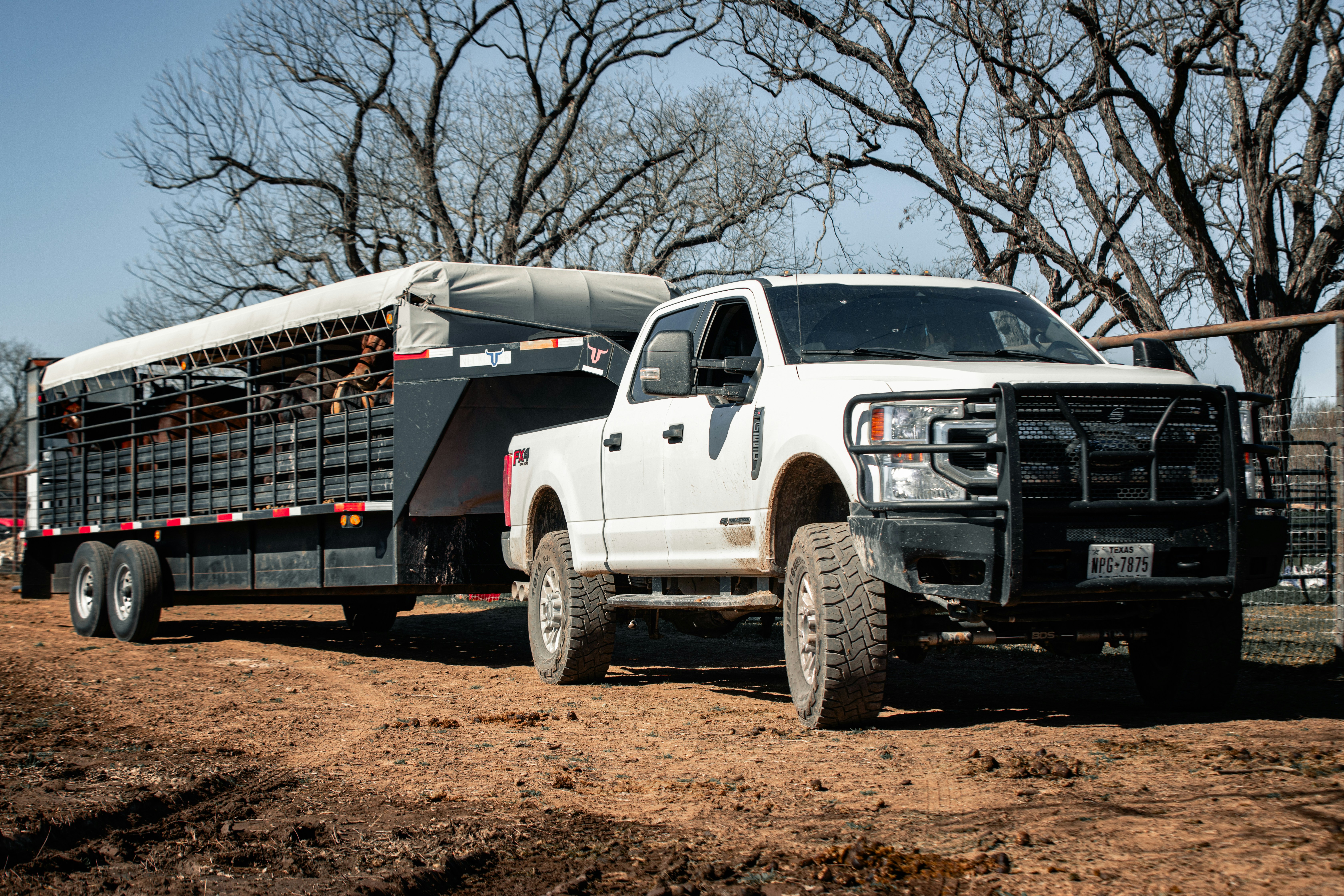 A white crew truck and trailer parked at the curb