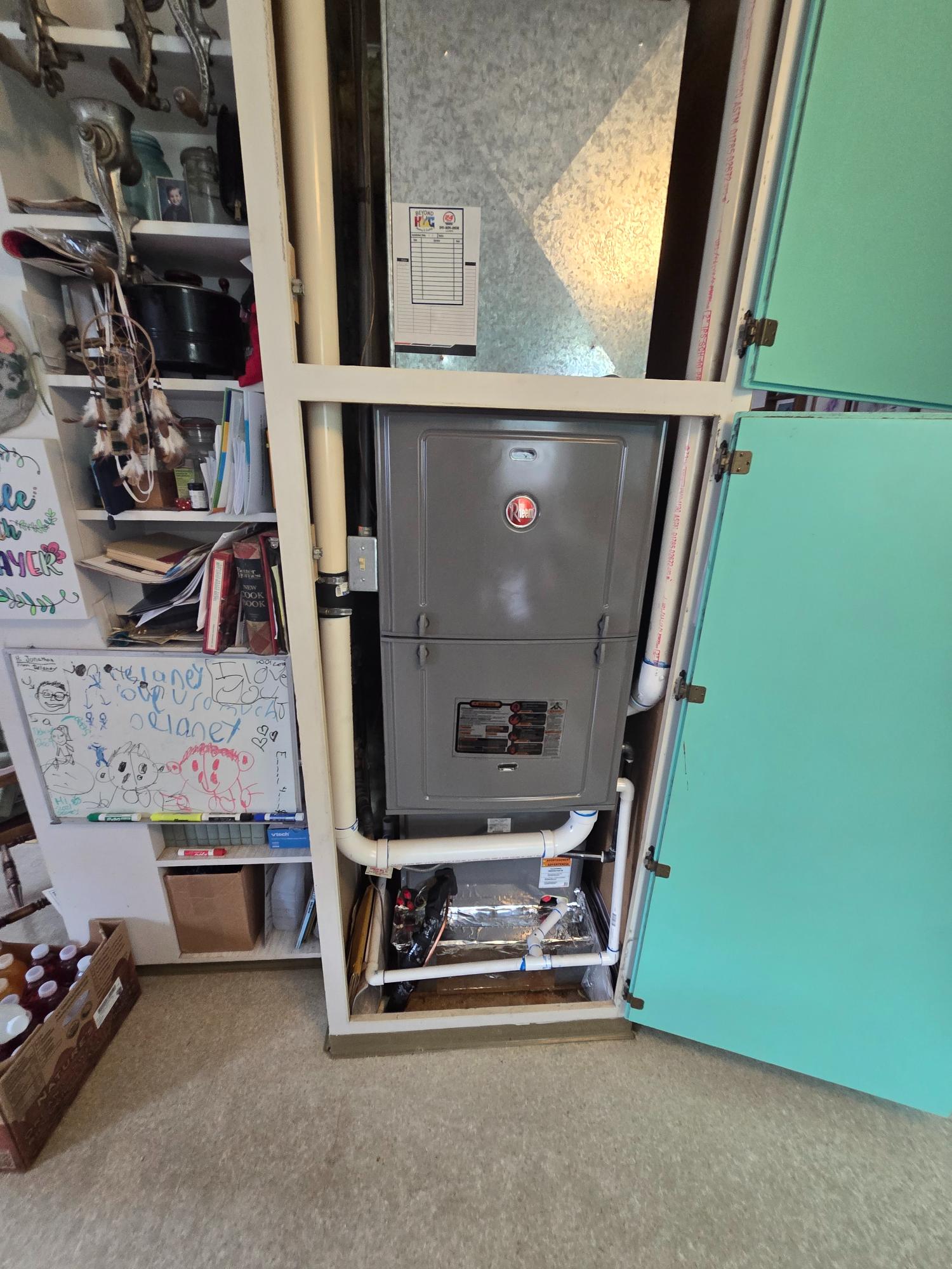 Rheem furnace system installed in a utility closet.