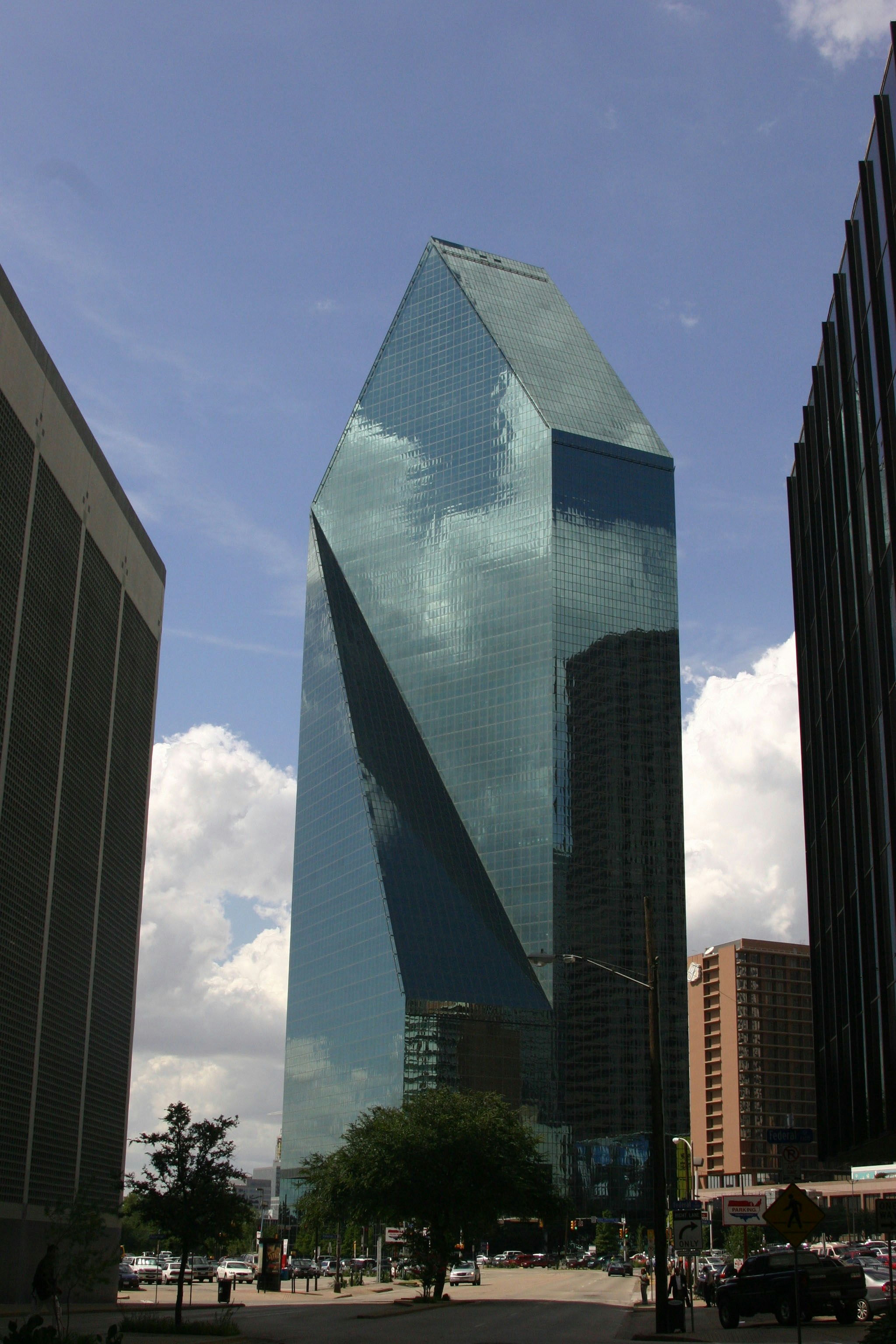 a tall glass building with Fountain Place in the background