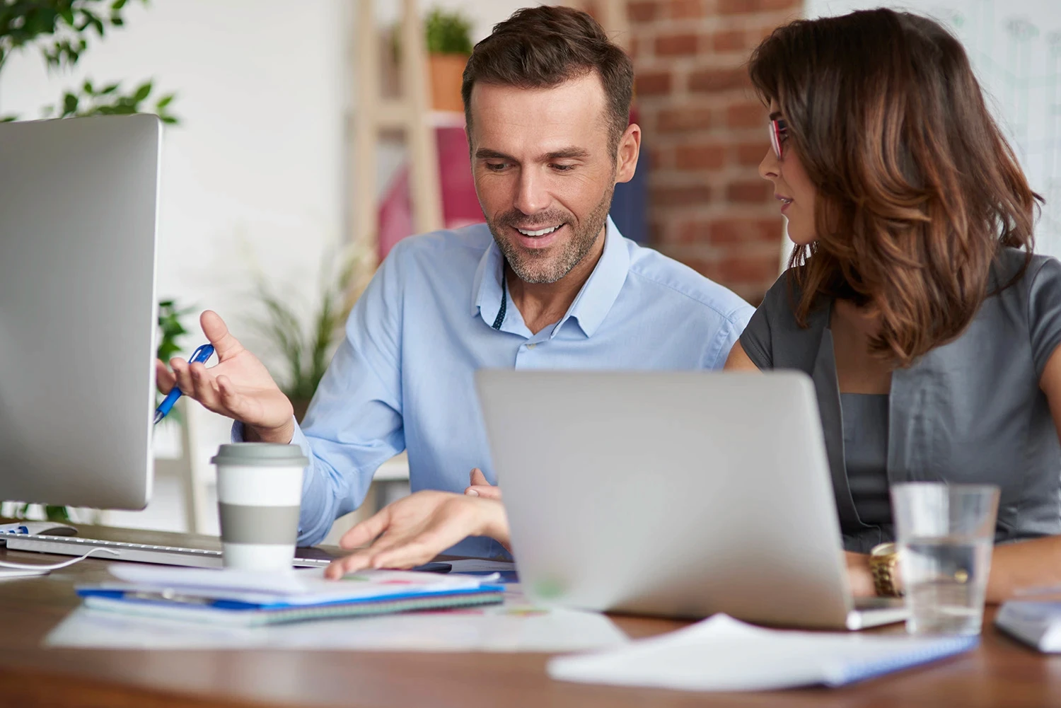 Man and woman discussing data together in an office setting.