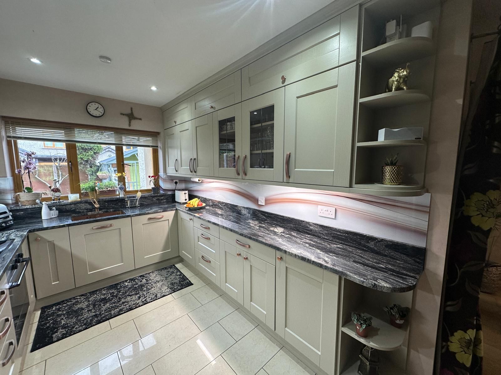 Spacious, luxurious living room with high ceilings, an elegant beige sectional sofa, warm ambient lighting, classical artwork, and rustic architectural elements, featuring an open layout with a view of a mezzanine level.