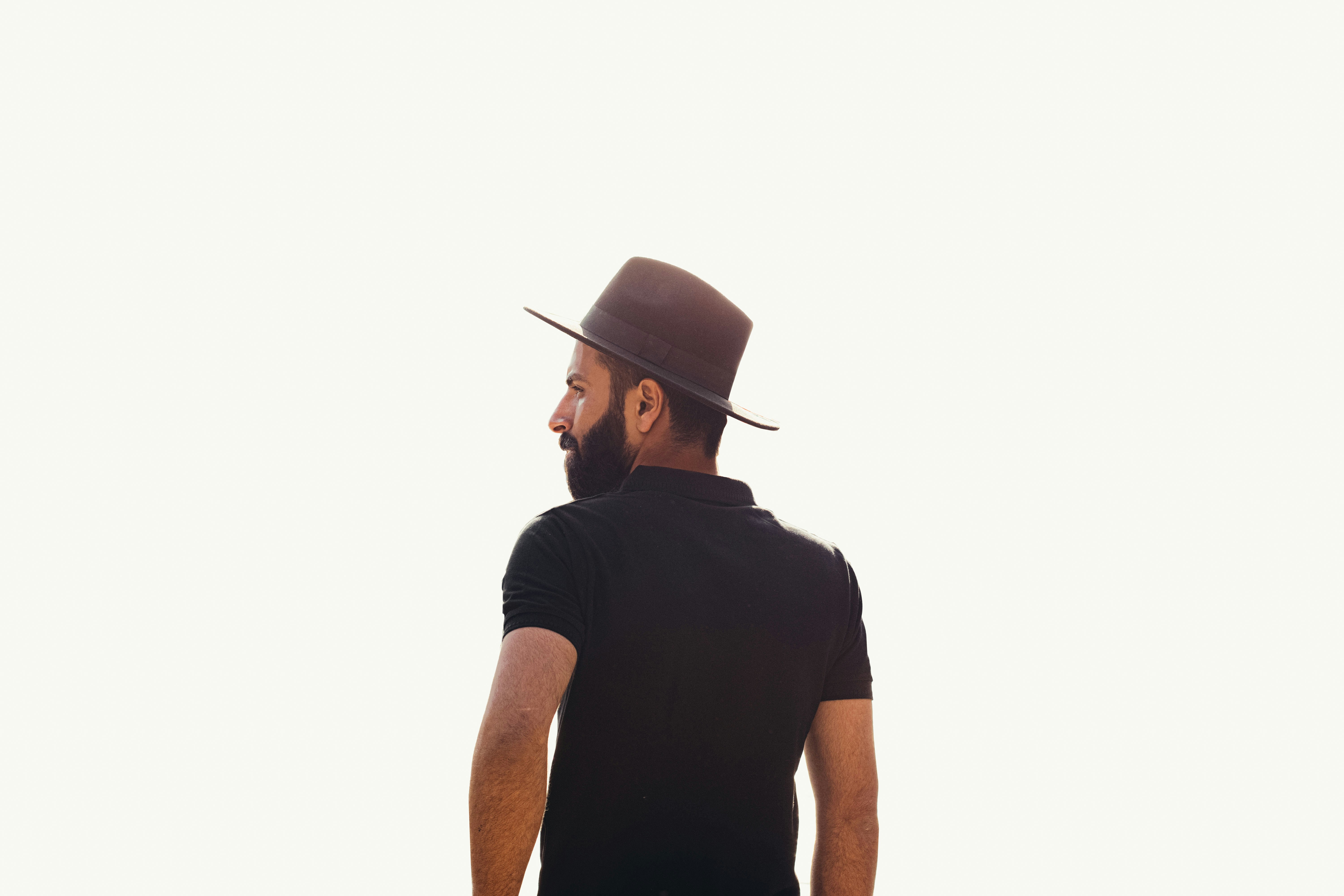 a man in a black shirt and a brown hat