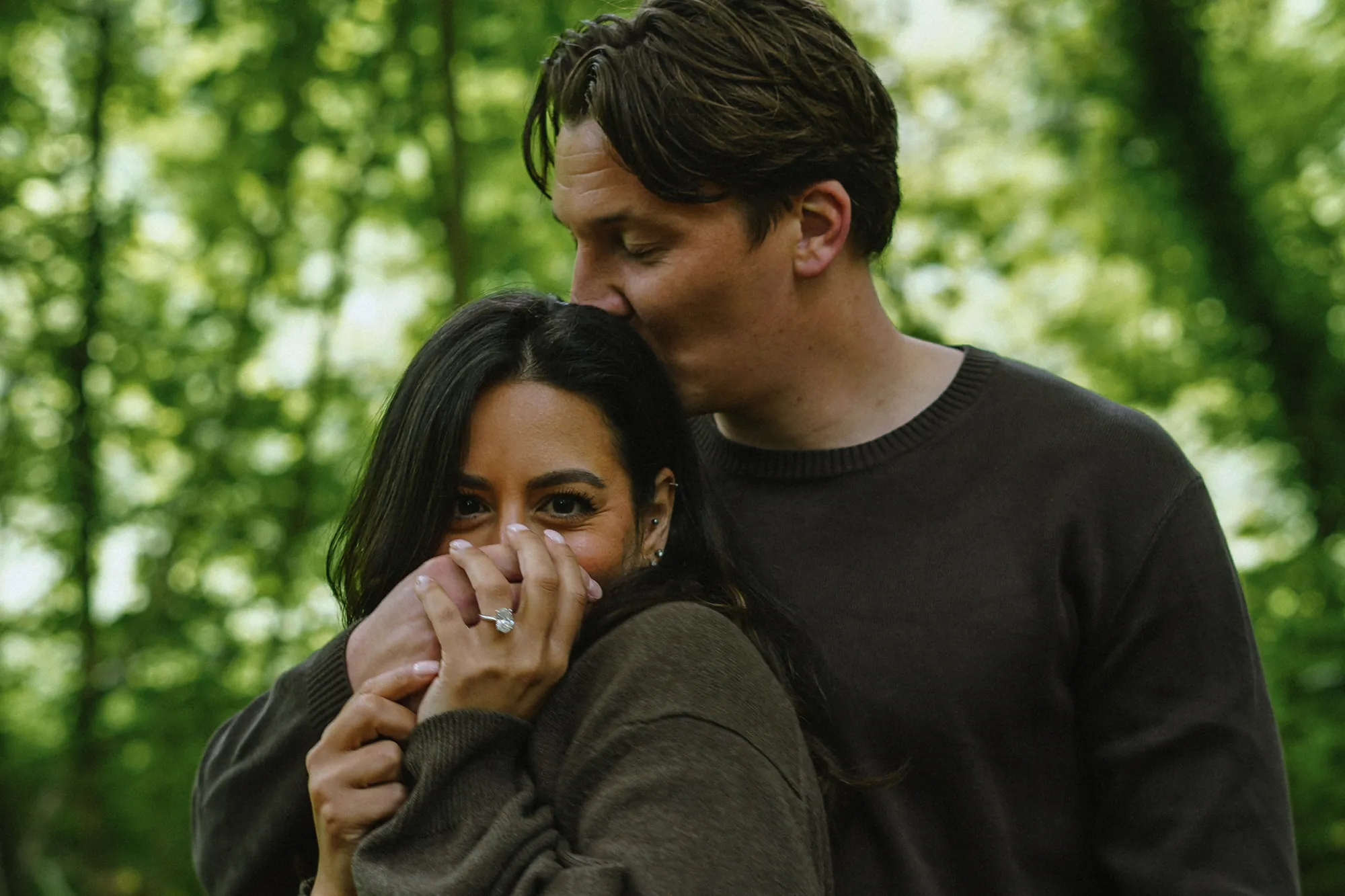 Connor and Cherine embracing in the woods