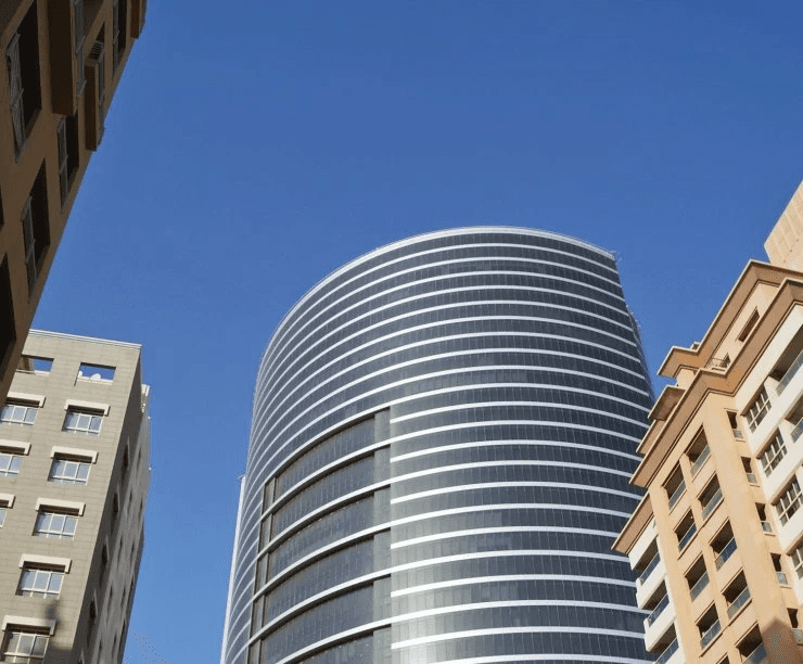 High-rise corporate building exterior with retail shops on ground floor, perfect for business growth.