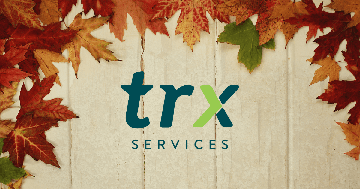 TRX logo on a wooden background surrounded by red and orange maple leaves
