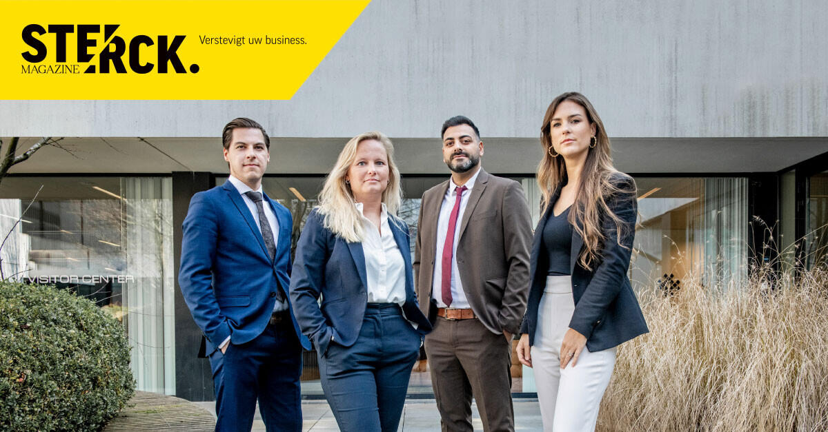 An image of four people in formal outfits in front of a building showing Le Grand & Associates