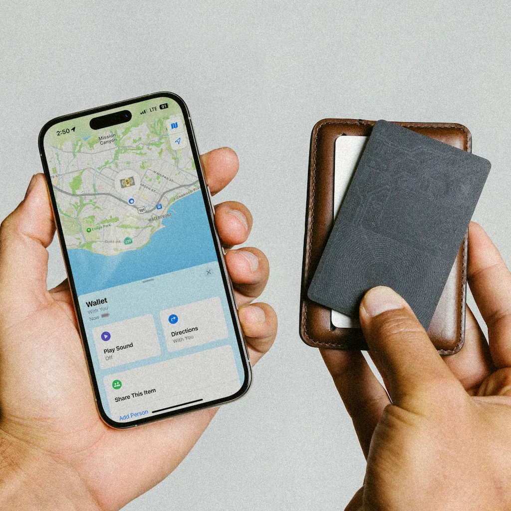 Person holding phone next to wallet and black card